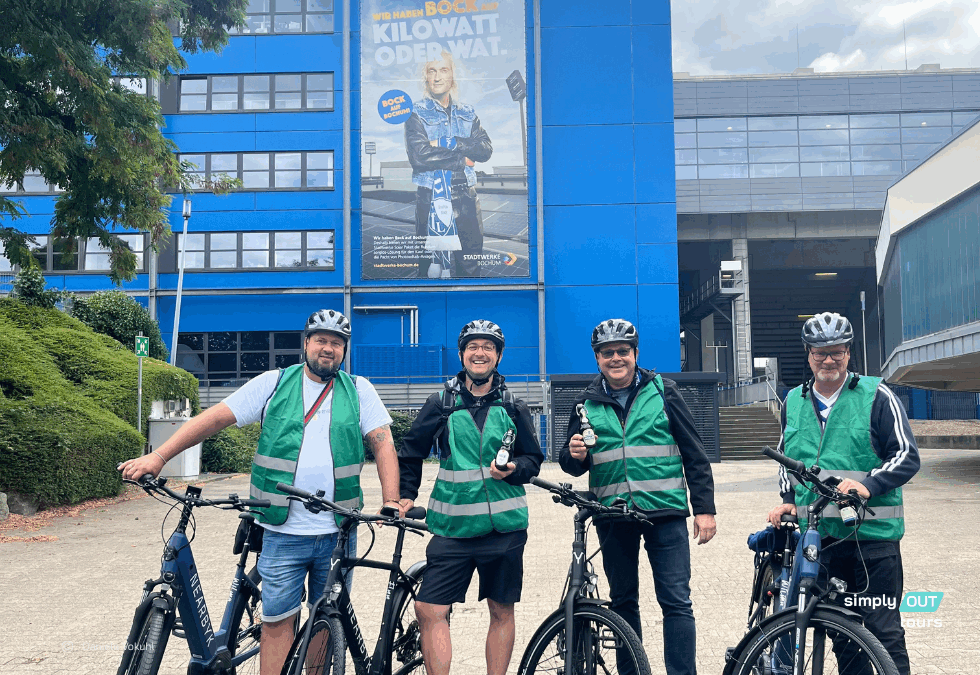 Eine Gruppe Männer in Warnwesten und mit Fahrräder vor dem Bochumer Stadion